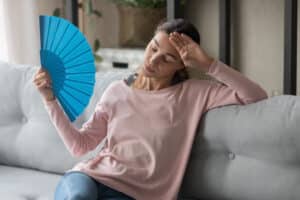A woman with a hormonal imbalance fanning herself