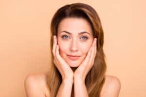 A woman touching her cheeks after getting PDO threads in Temecula, CA