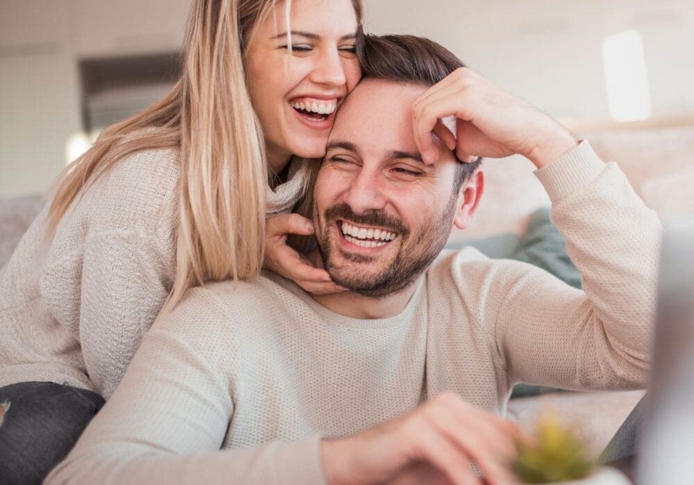 hormone replacement therapy Happy couple smiling and enjoying a moment together at home, reflecting on improved mood and relationship quality through hormone replacement therapy.